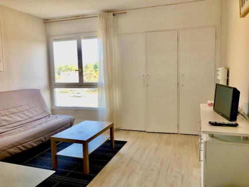 un salon avec un canapé et une table dans l'établissement Studio - Pleine Mer - 1 avenue des Pays de Monts - 1-1, à Saint-Jean-de-Monts