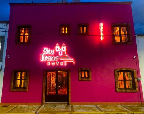 a pink building with a neon sign on it at Hotel Santa Irene in Cholula