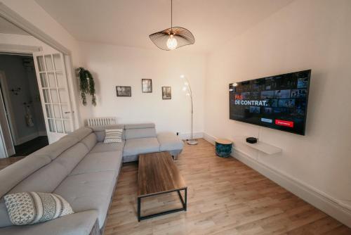 uma sala de estar com um sofá e uma televisão de ecrã plano em Appartement d'Alexandre hyper centre-ville em Charleville-Mézières