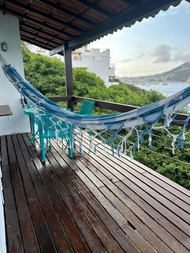 a hammock on a deck with a view of the ocean at Pousada Vista Grega in Arraial do Cabo