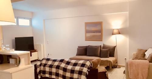 a small living room with a couch and a television at Maria’s Home in Piraeus