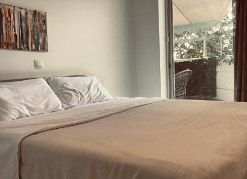 a bed in a bedroom with a view of a window at Maria’s Home in Piraeus