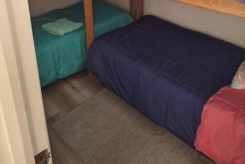 1 dormitorio con cama azul y sábanas verdes en Apto. Reñaca 193 - Viña del Mar en Viña del Mar