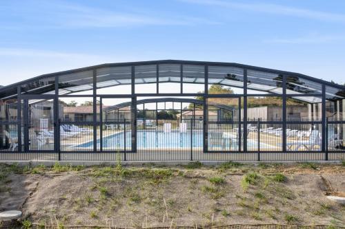 a large metal building with a pool in it at Le Chalet Sessanta - Welkeys in Saubrigues
