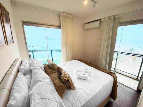 a bedroom with a large bed with a large window at 30 secs to the beach, 3 balconies, 2 bdrms ensuite in Rio de Janeiro