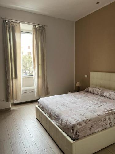 sypialnia z dużym łóżkiem i oknem w obiekcie La Piazzetta Anzio w Anzio