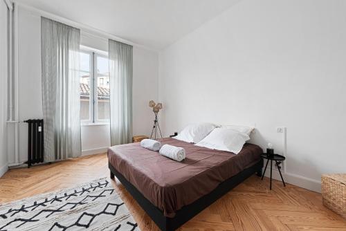une chambre blanche avec un grand lit et une fenêtre dans l'établissement CentreVille T3 Cosy French Style, à Carcassonne