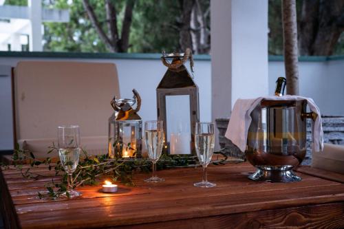 a wooden table with wine glasses and a lantern at Villa Dyrrahu in Golem