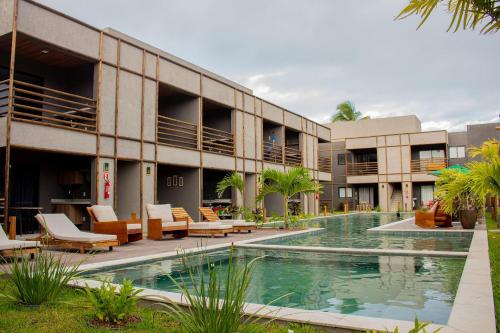 un complexe avec une piscine en face d'un bâtiment dans l'établissement Gamboa Patacho Apto 002 Bloco B - ER Hospedagens, à Porto de Pedras