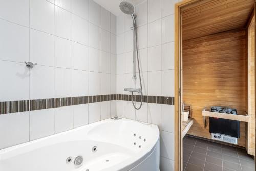 a bathroom with a white tub and a shower at AirHome - The Admiral House in Tallinn