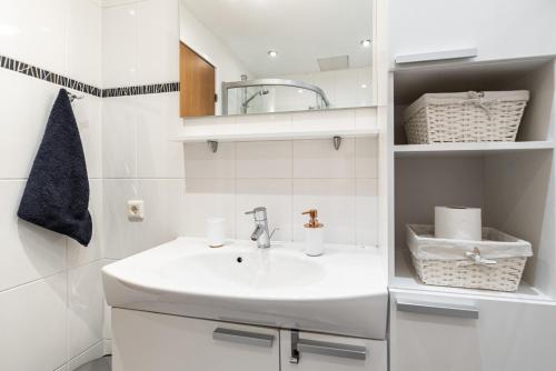 a white bathroom with a sink and a mirror at AirHome - The Admiral House in Tallinn