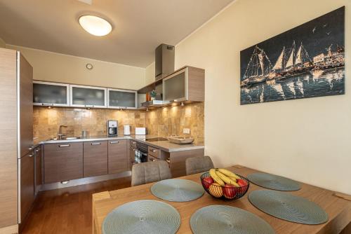 a kitchen with a wooden table with a bowl of fruit on it at AirHome - The Admiral House in Tallinn