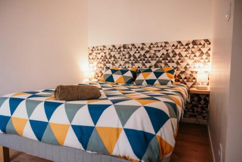 a bedroom with a large bed with a colorful comforter at Appartement de Thomas in Charleville-Mézières