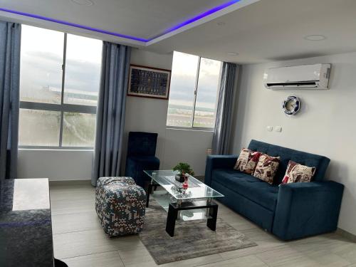 een woonkamer met een blauwe bank en een glazen tafel bij Apartamento nuevo en Barranquilla in Barranquilla