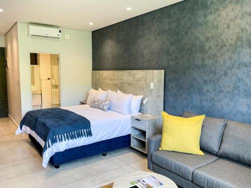 a bedroom with a bed and a couch at Zimbali Lakes Boulevard Suites 220 in Ballito