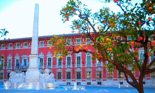 a large red building with a monument in front of a tree at The small waterfall house, la cascatella in Massa