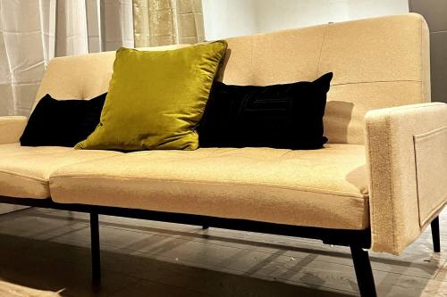 a couch with two yellow and black pillows on it at Garden Eleven - Duplex City Centre Apartment in Hemel Hempstead