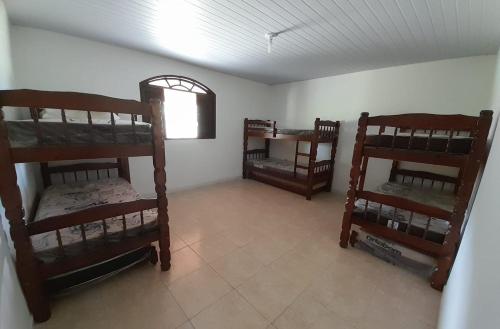 Zimmer mit Etagenbetten in einem Zimmer mit Fenster in der Unterkunft Sítio Vivendo & Aprendendo in Tanguá