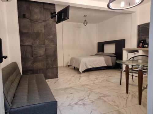 - un salon avec un lit et une table en verre dans l'établissement Depa para 2 personas con aire acondicionado, à Manzanillo