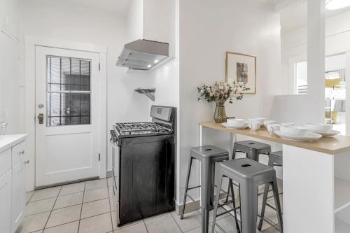 a kitchen with a stove and stools in it at Urban oasis close to Bart, shops, restaurants in oakland in Oakland