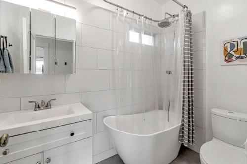 a white bathroom with a tub and a sink at Urban oasis close to Bart, shops, restaurants in oakland in Oakland