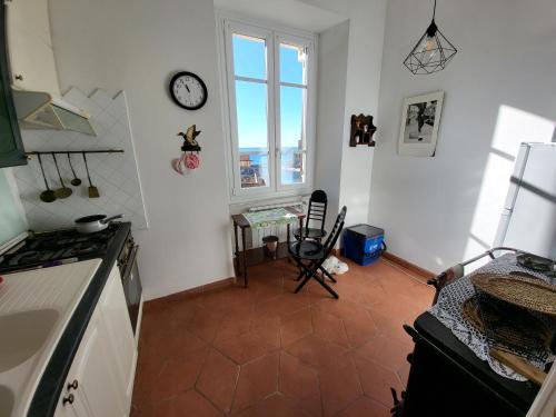 a kitchen with a clock on the wall and a window at Monterosso Servano's Villas in Monterosso al Mare