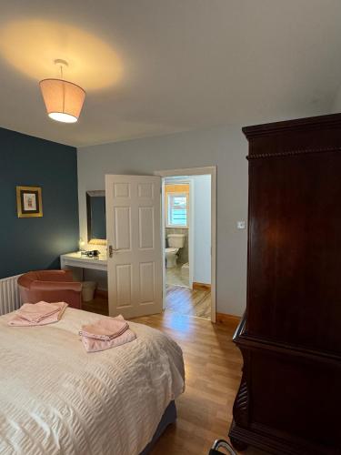 a bedroom with a bed and a room with a desk at Aherlow Valley Hideaway in Tipperary