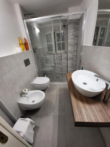 a bathroom with two sinks and a toilet and a shower at Monterosso Servano's Villas in Monterosso al Mare