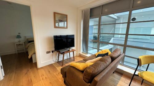 a living room with a couch and a large window at Modern & stylish 1 bedroom flat in London