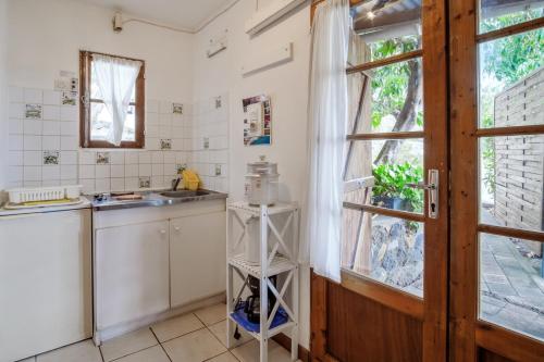 a kitchen with a sink and a window at Bungalow charmant à Saint Paul avec vue sur la mer in Fleurimont