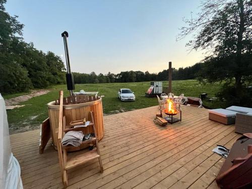 a wooden deck with a grill and a fire place at Open Sky Glamping Kawartha Dome in Marmora