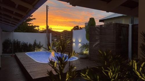 bañera de hidromasaje en una terraza con puesta de sol al fondo en Casa 4 quartos piscina praia Mariscal Bombinhas SC, en Bombinhas
