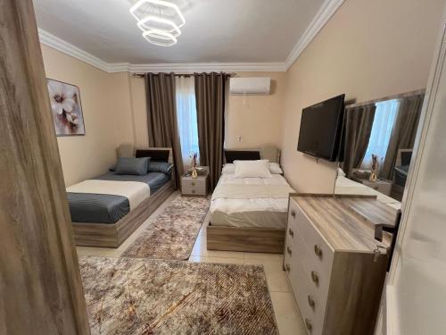 um quarto de hotel com duas camas e uma televisão em Luxurious VIP apartment in Madinaty furnished with high end hotel furniture em Madinaty