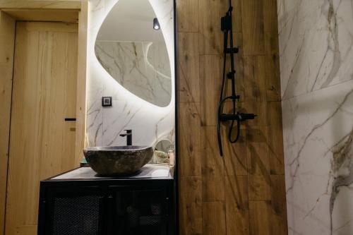 a bathroom with a bowl sink and a mirror at Azalea Chalet in Divčibare