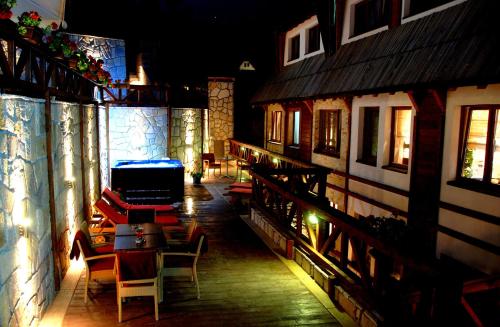 a patio with chairs and tables on a building at night at Apart & Spa Zoned in Kopaonik