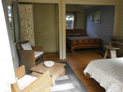 um quarto com uma cama, uma mesa e cadeiras em Le Jardin de Beau Vallon em Mahébourg