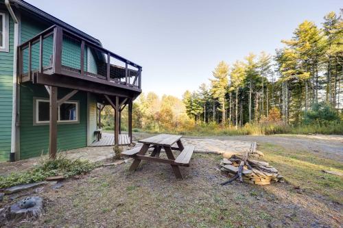 a picnic table in front of a house with a balcony at Unique West Jefferson Home with Fire Pit and Grill! in West Jefferson