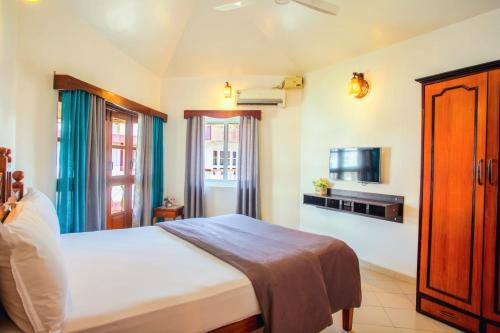 a bedroom with a large bed and a tv at 'Golden Sand Dunes' 1bhk Benaulim beach apartment in Madgaon