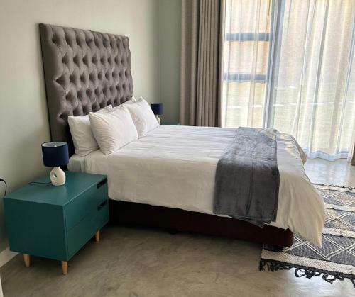 a bedroom with a large bed and a blue night stand at Sango on 9 in Naboomspruit