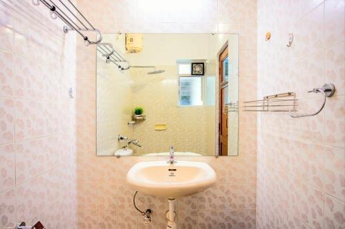 a bathroom with a sink and a mirror at 'Golden Sand Dunes' 1bhk Benaulim beach apartment in Madgaon