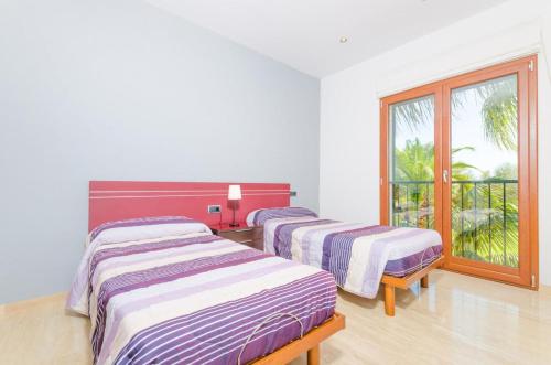 セス・サリネスにある4 bedrooms villa with private pool enclosed garden and wifi at Illes Balears 8 km away from the beachのバルコニー付きの客室内のベッド2台