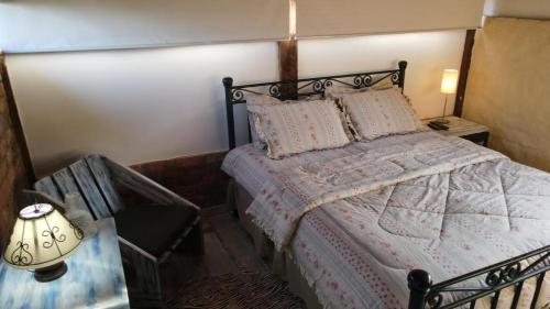 een slaapkamer met een bed en een lamp erin bij Cabaña Yerbabuena in Toca