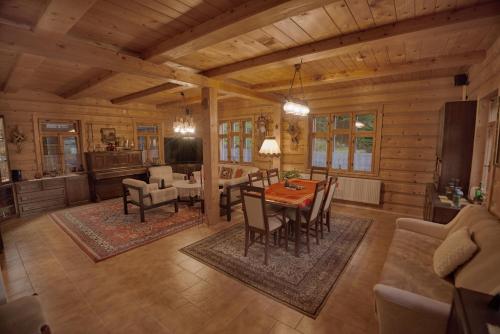 a dining room and living room of a log cabin at Chata Štefička in Josefuv dul