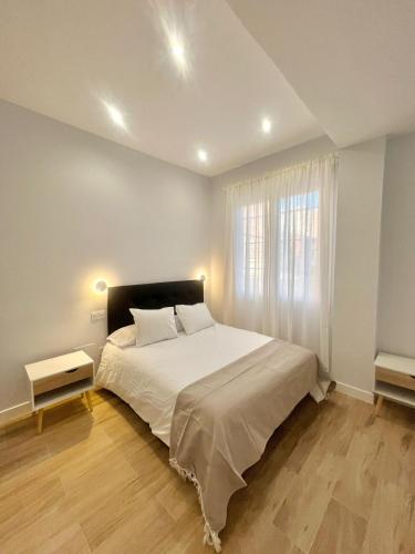 a bedroom with a large white bed with a window at Lofts IFEMA in Madrid