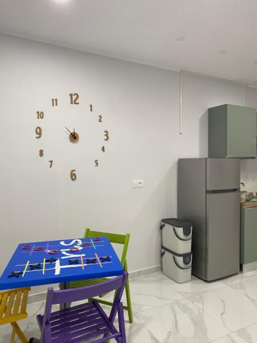 a kitchen with a table and a clock on the wall at Isla Home in Naples