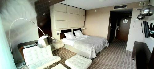 una habitación de hotel con una cama y una silla en Prywatny Apartament Marine Hotel, en Kołobrzeg