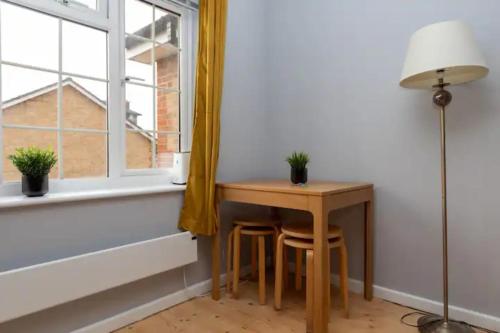 a small table with two stools next to a window at Newly Refurbished 2BD Flat wParking - Peckham! in London