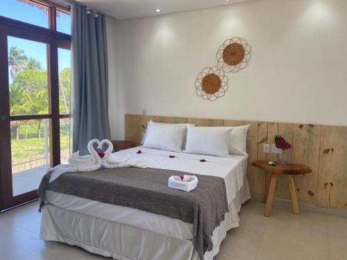 a bedroom with a bed with towels on it at Pousada Canouan in Japaratinga