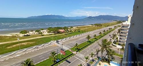 an empty street next to a beach with a building at Casa Praia Indaia in Caraguatatuba