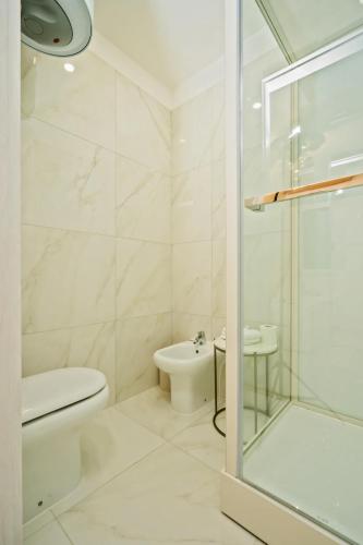 a white bathroom with a toilet and a shower at infinity Castellabate b & b di Charme in Santa Maria di Castellabate